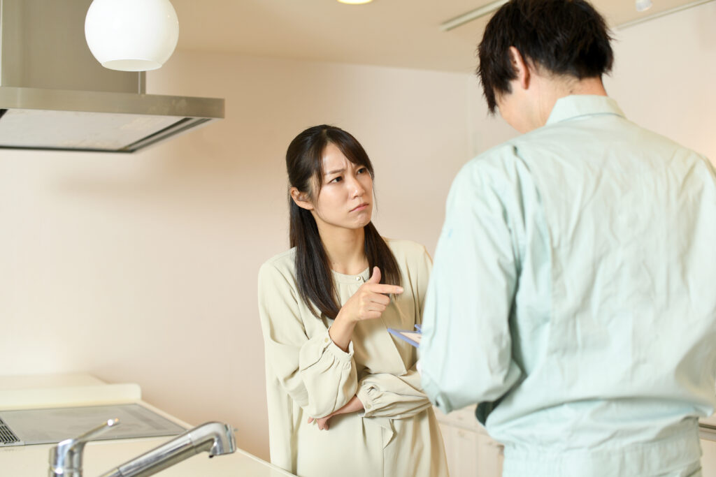 業者の男性と不服そうな表情の女性
