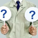 クエスチョンマークの札を持つ男性